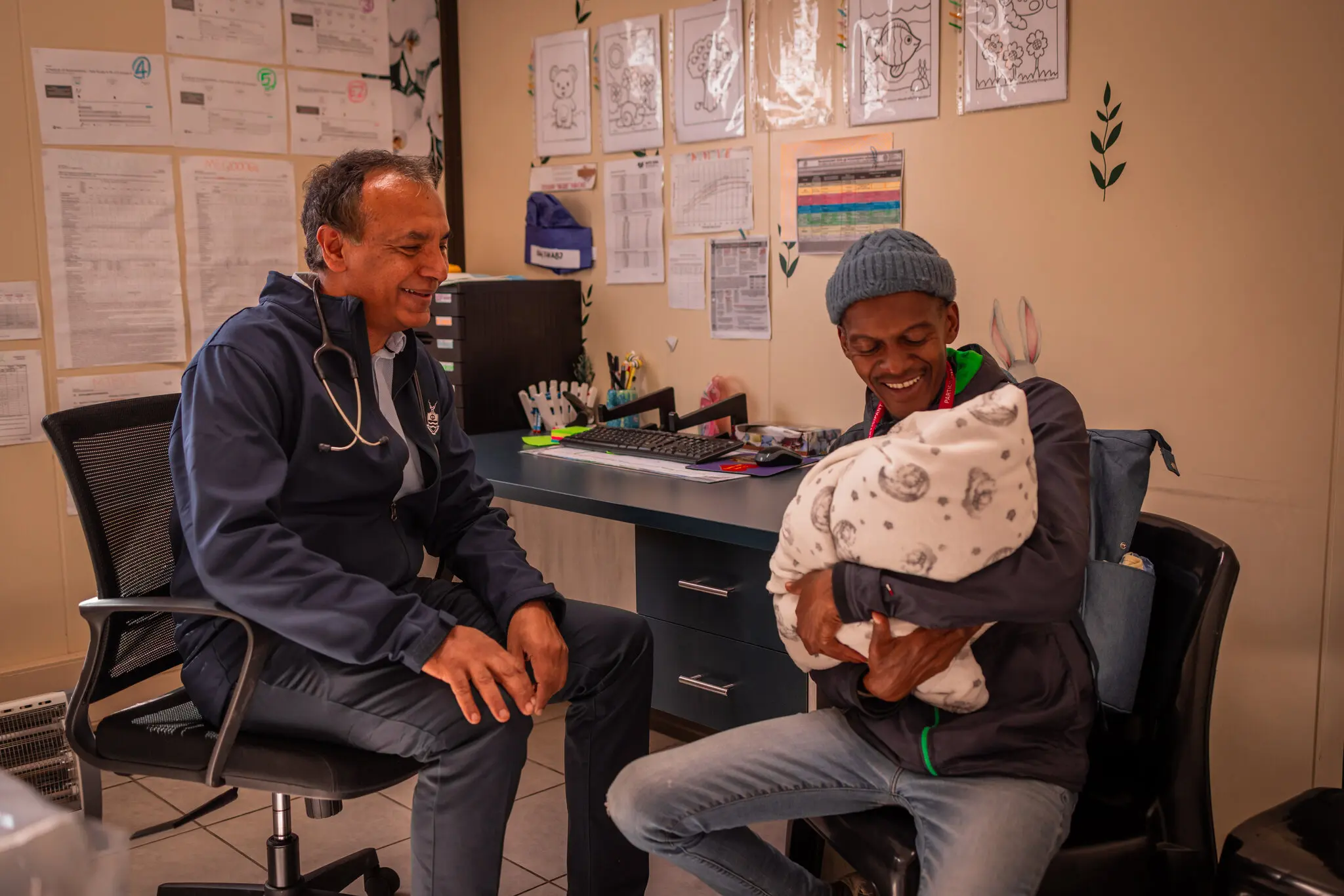 Доктор Шабір Мадхі, декан факультету медичних наук Університету Вітватерсранда в Йоганнесбурзі, з Полом Мобейном, який привів свою 3-денну доньку, щоб отримати експериментальну вакцину.